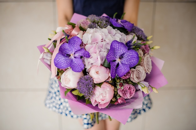 Niña sosteniendo un ramo de flores de color púrpura en las manos