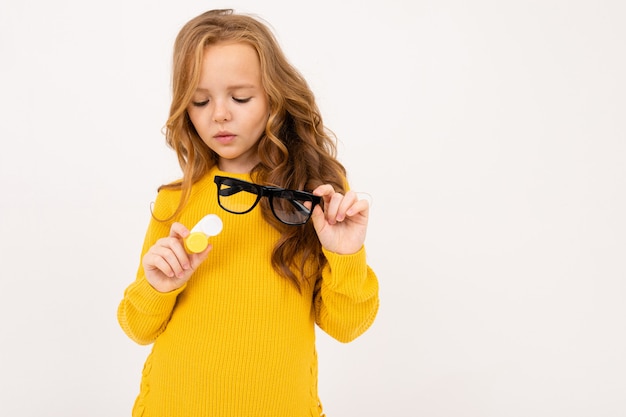 Niña sosteniendo un recipiente para lentes y gafas en su mano