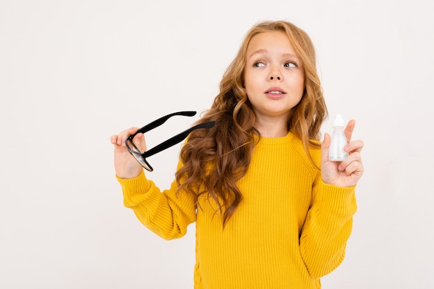 Niña sosteniendo un recipiente para lentes y gafas en su mano