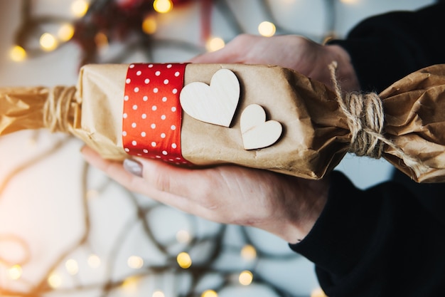 niña sosteniendo un regalo de Navidad en la mano