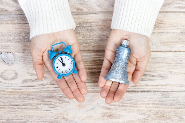 Una niña sosteniendo un reloj y una campana