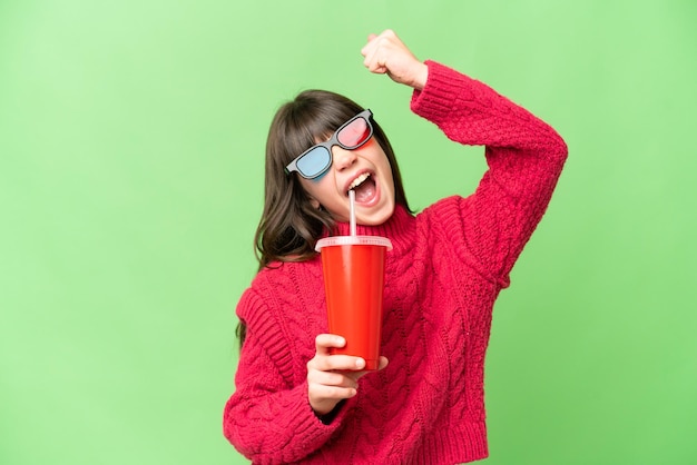 Niña sosteniendo soda sobre un fondo clave de croma aislado celebrando una victoria