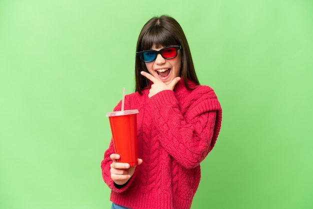 Niña sosteniendo soda sobre fondo clave de croma aislado feliz y sonriente