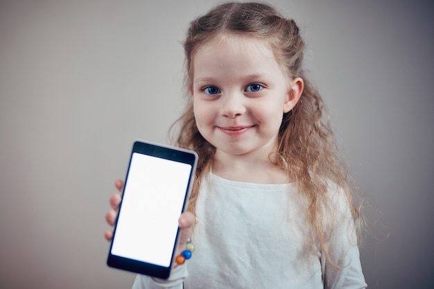 Niña sosteniendo un teléfono inteligente con una pantalla blanca