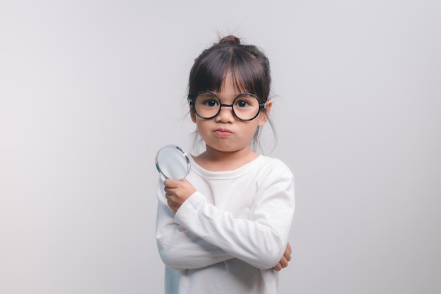 Niña sosteniendo a través de una lupa