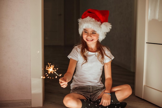 una niña sostiene bengalas en el sombrero de Papá Noel el milagro de la Navidad