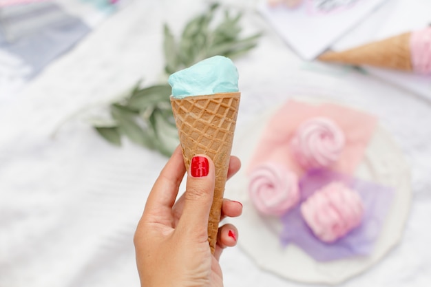 Niña sostiene un cono de helado de mentol en la mano