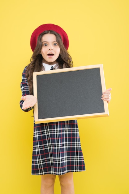 Niña sostiene pizarra en blanco Espacio de copia de producto publicitario Concepto de regreso a la escuela Información escolar Informarte Espera lo inesperado Tablero de información promocional para niños Lugar para obtener información