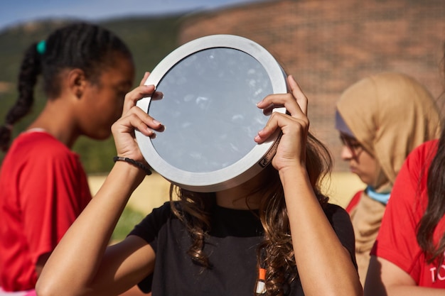 Una niña sostiene un plato para ver un eclipse solar.