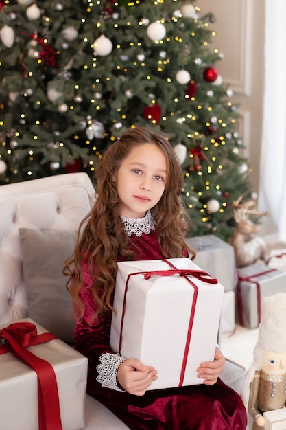 Niña sostiene un regalo de Navidad