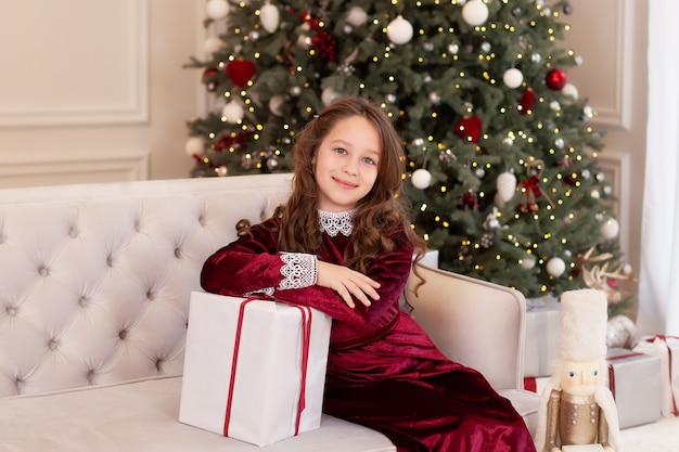 Niña sostiene un regalo de Navidad