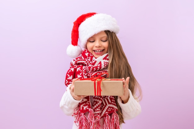 Una niña sostiene su regalo de Navidad y sonríe. Un niño disfrazado de año nuevo.