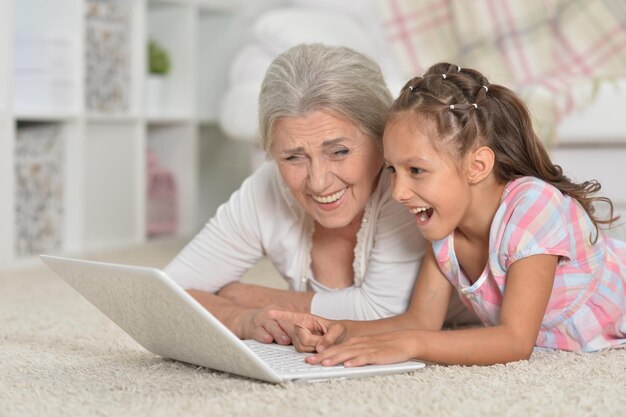 Niña con su abuela usando laptop