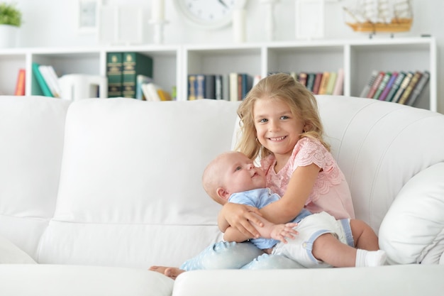 Niña con su hermana recién nacida en el sofá