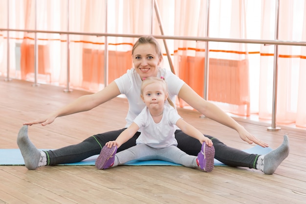 Una niña y su madre están haciendo deporte.