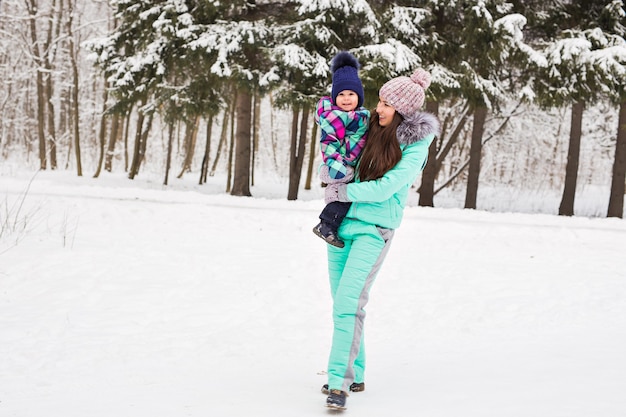 Niña y su mamá se divierten en un día de invierno.