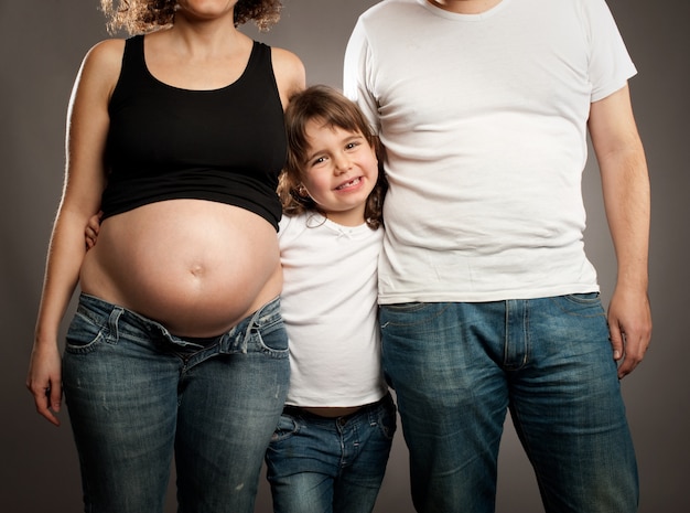 niña con su padre y madre embarazada