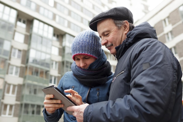 Niña y su padre con una tableta en las manos buscando el camino correcto en la ciudad