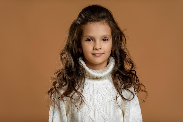 Niña en suéter blanco mirando a la cámara