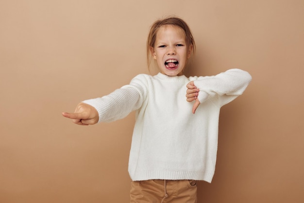 Niña en suéter blanco posando gestos con las manos Estilo de vida inalterado