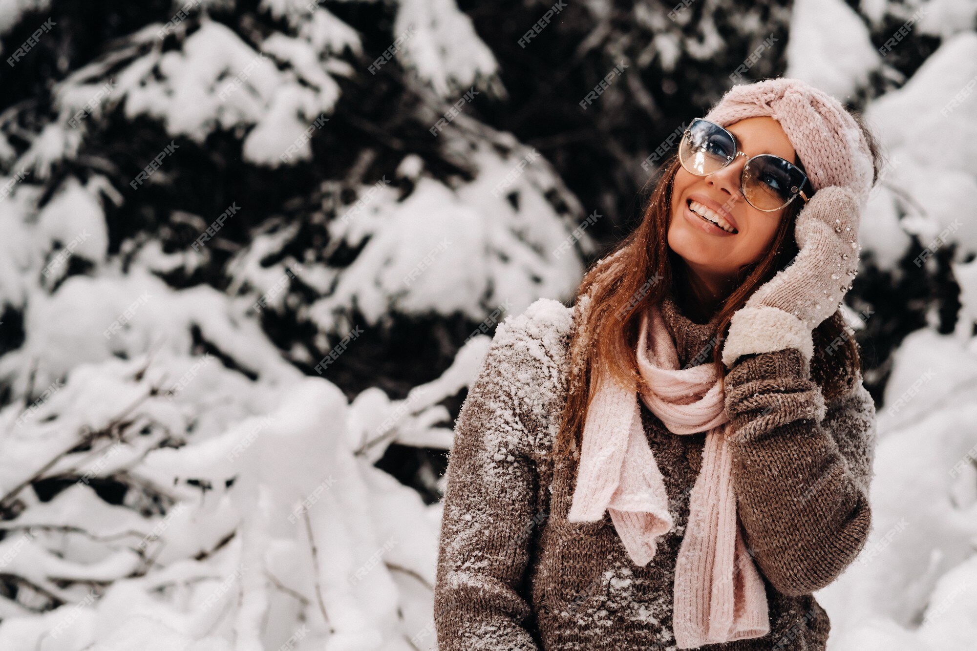 Una niña con un suéter y gafas en invierno en un bosque cubierto de nieve