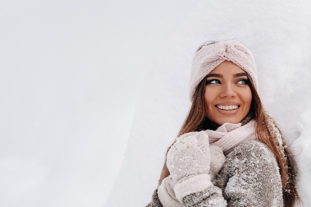 Una niña con un suéter y guantes en invierno.