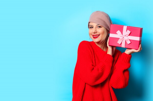 niña de suéter rojo con caja de regalo