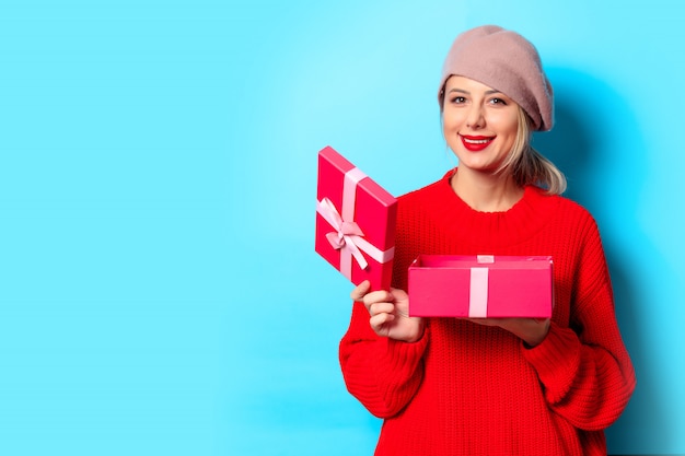 niña de suéter rojo con caja de regalo