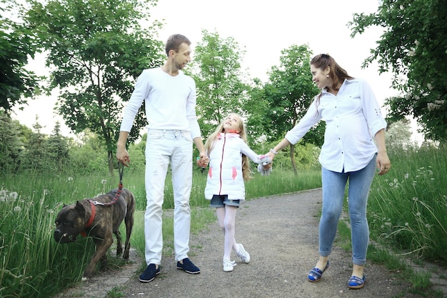 Niña con sus padres y perro mascota en el parque