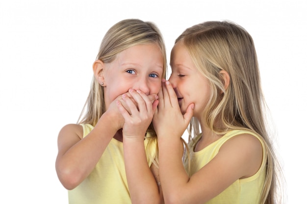 Niña susurrando a su hermana