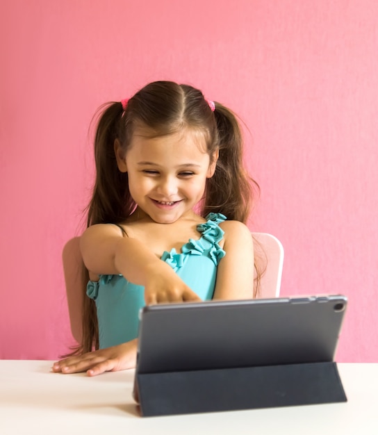 Foto niña con una tableta en la mesa