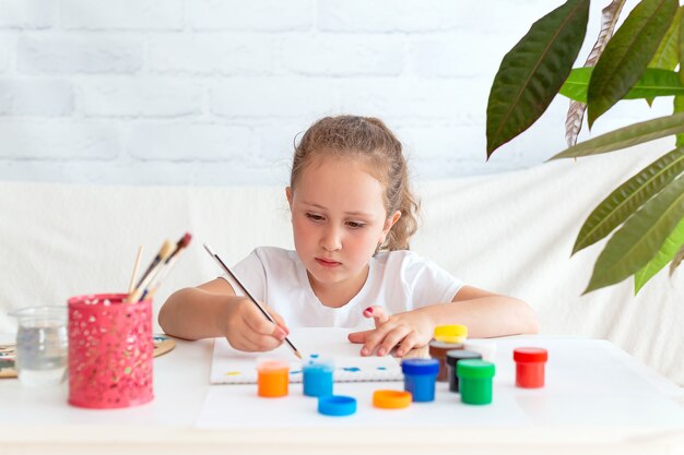 Una niña talentosa hace bocetos de un dibujo con un lápiz.