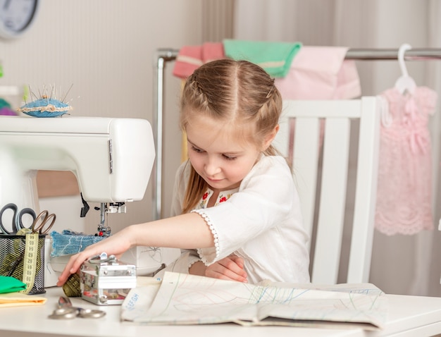 Foto niña en un taller de costura