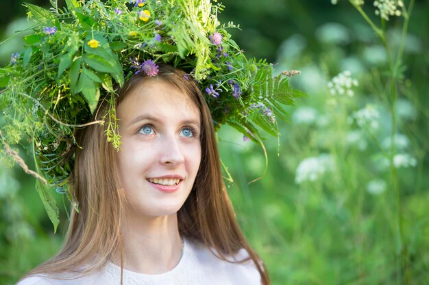 La niña teje una corona para las vacaciones de verano eslavas nocturnas de Kupala Mujer bielorrusa o ucraniana