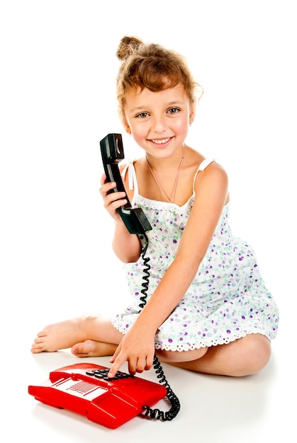 Niña con teléfono aislado sobre un fondo blanco.