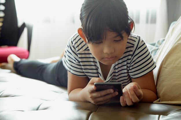 Niña con teléfono inteligente en casa