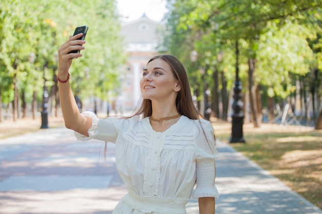 Una niña con un teléfono inteligente en sus manos en el fondo de un edificio antiguo