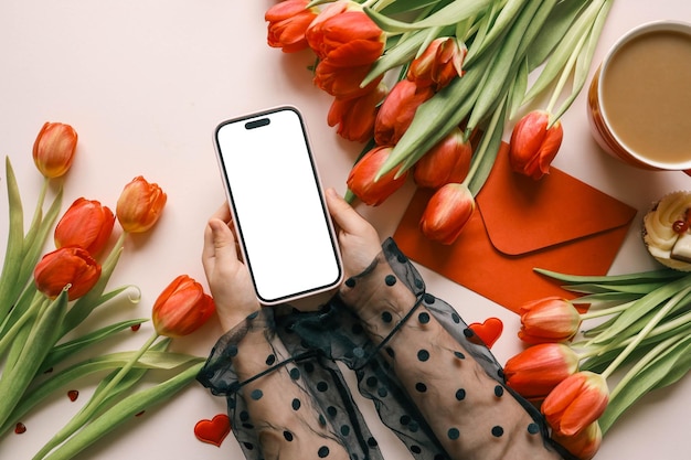 Niña con un teléfono en sus manos con una pantalla aislada sobre un fondo de flores