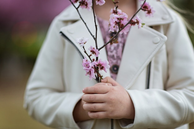 Niña, tenencia, rama, de, floreciente, flores, primer plano