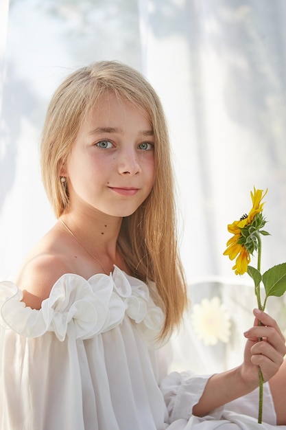 Niña en tienda de gasa blanca con girasol