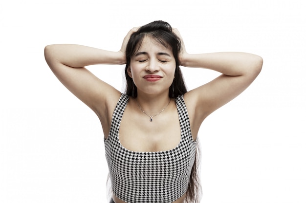 Una niña tiene las manos detrás de la cabeza con los ojos cerrados.