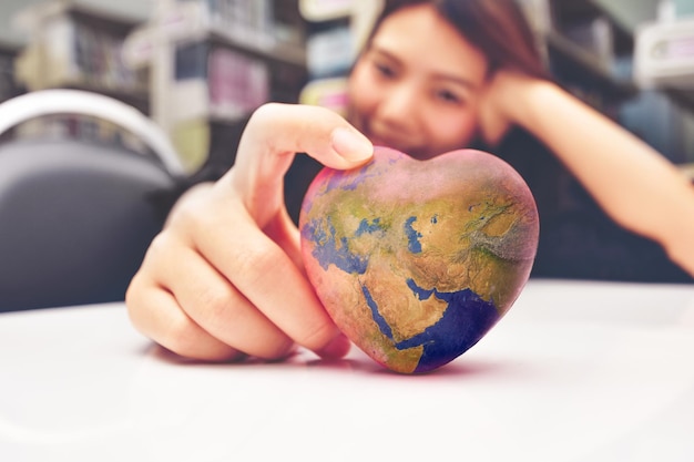 La niña tiene un mundo en forma de corazón en la mano Proteccionismo mundial