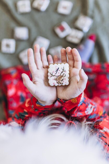 Una niña tiene pan de jengibre de Navidad en sus manos