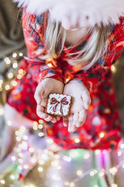 Una niña tiene pan de jengibre de Navidad en sus manos