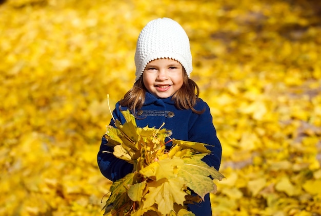 Niña tirando hojas de otoño