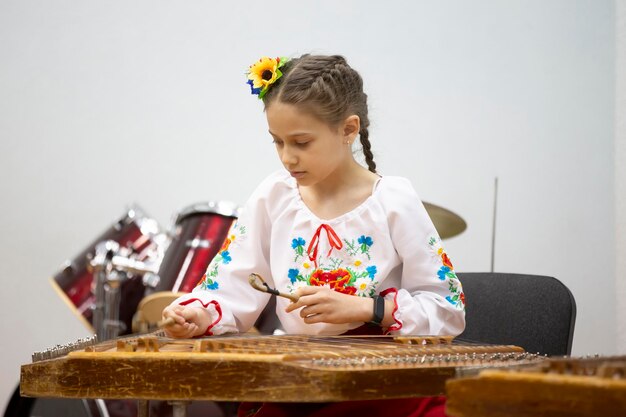 Foto la niña toca el instrumento étnico dulcémele