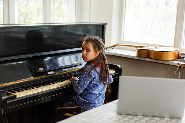 la niña toca el piano viejo en la casa vieja