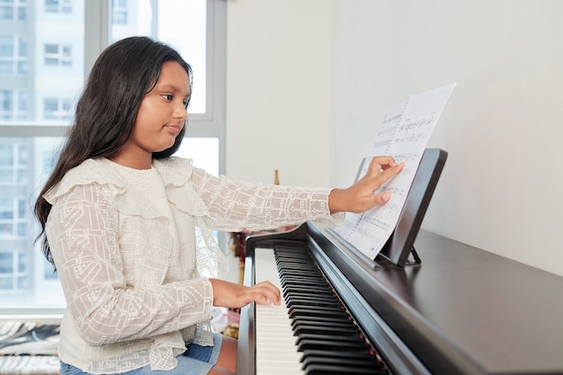 Foto niña tocando la composición en el piano