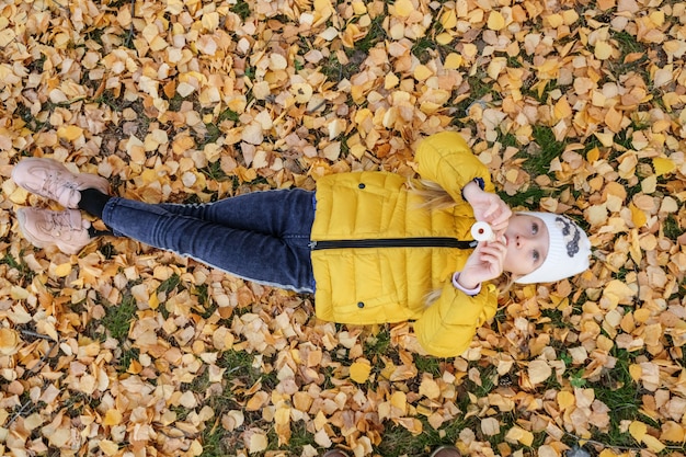 Foto niña tocando un instrumento musical en el bosque de otoño