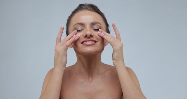 Foto niña tocando su rostro mujer con piel perfecta sobre fondo gris tratamiento para el cuidado de la piel o concepto de anuncios cosméticos